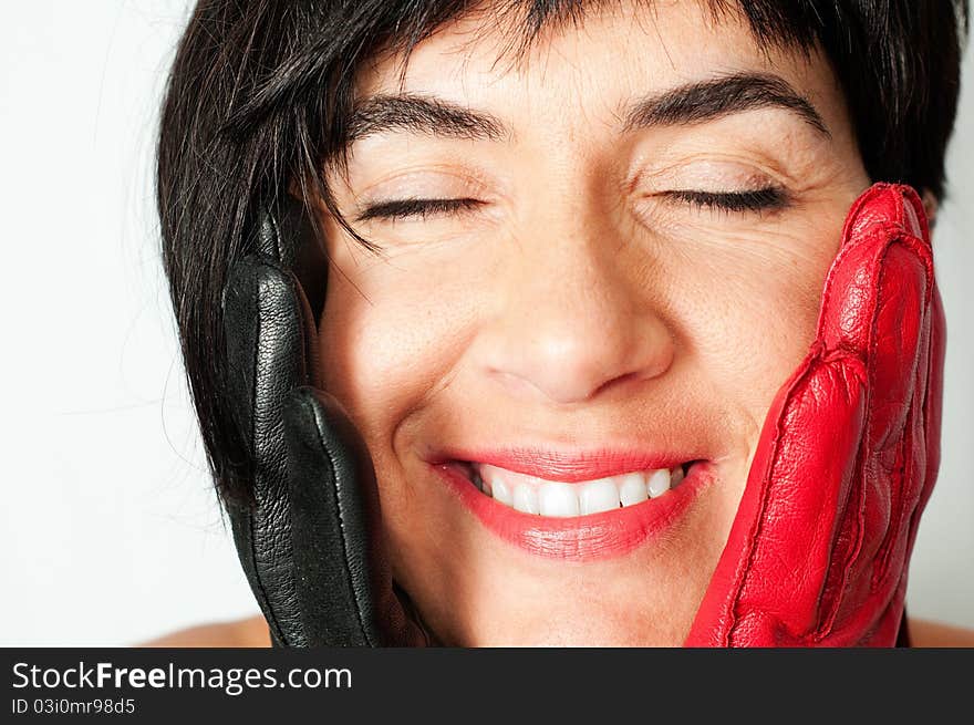 A girl with red gloves and black and her eyes closed with a look of happiness and inner joy