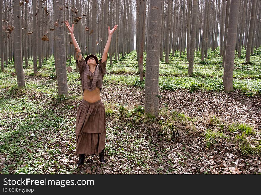 A girl by blowing the leaves of the trees in the forest. Symbol of Freedom. A girl by blowing the leaves of the trees in the forest. Symbol of Freedom