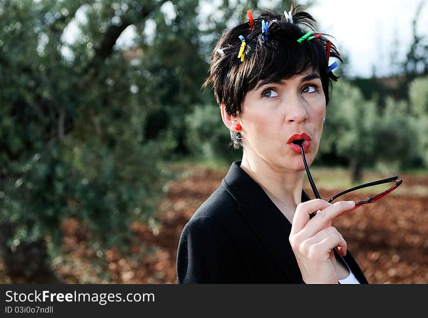 Funny picture of a girl with her hair adorned with clothespins, wearing cheerful sunglasses subject with her hands. Funny picture of a girl with her hair adorned with clothespins, wearing cheerful sunglasses subject with her hands.