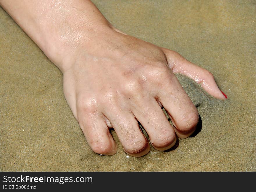 Female hand grabbing sand closeup on seaside outdoors