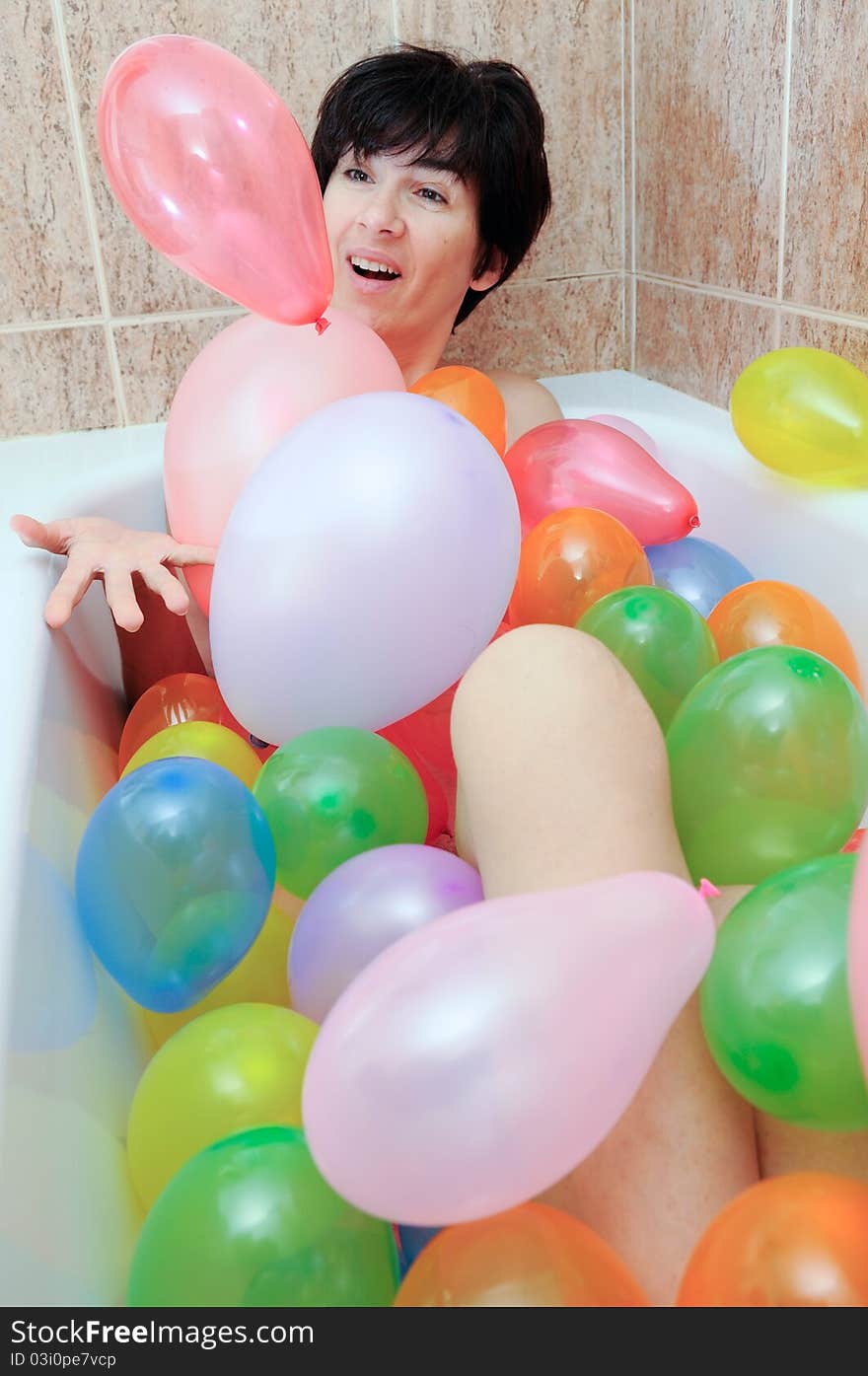 Woman playing with balloons in his bathtub. Woman playing with balloons in his bathtub