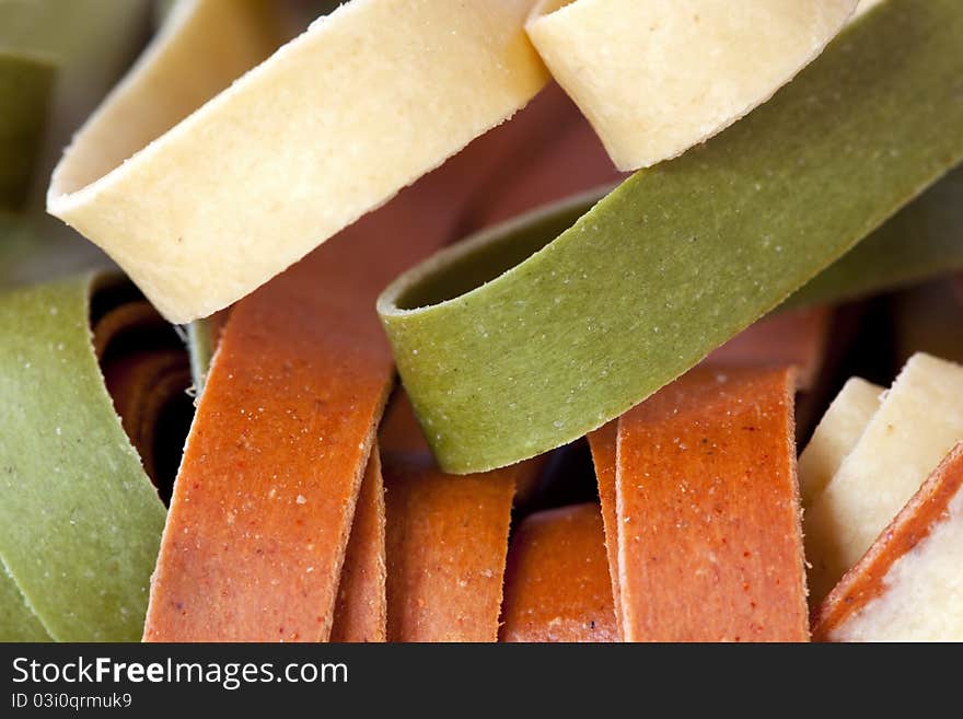 Dried colorful fettucine. Plain, tomato and spinach, in closeup. Dried colorful fettucine. Plain, tomato and spinach, in closeup.