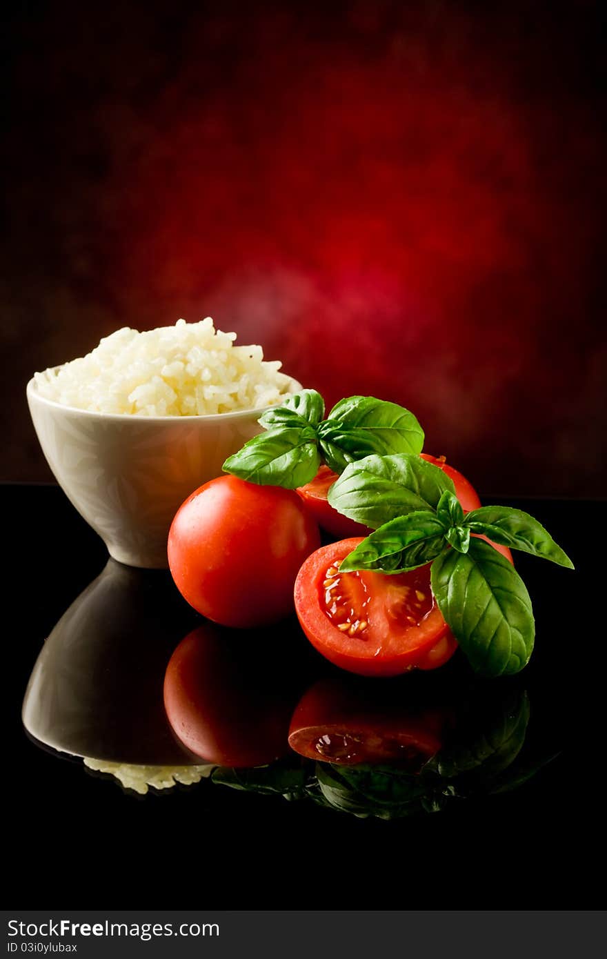 Photo of rice inside a bowl with basil and fresh cherry tomatoes. Photo of rice inside a bowl with basil and fresh cherry tomatoes