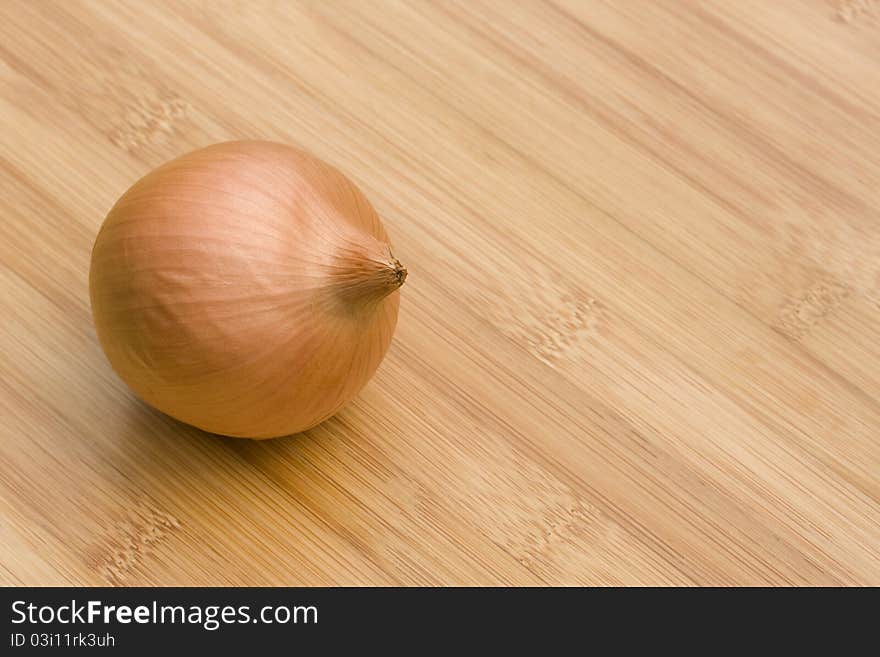 Whole brown onion on wooden table