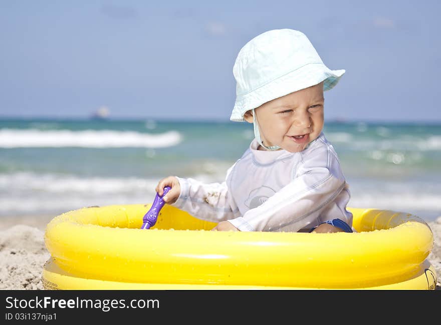 Baby playing with toys in pool on a beach. Baby playing with toys in pool on a beach