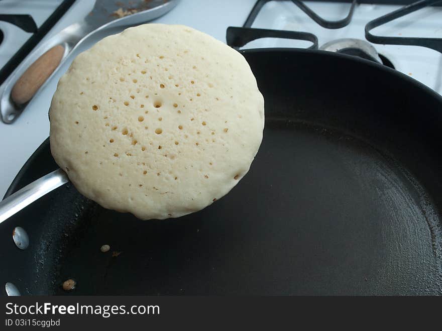 Pancake being flipped to cook on other side. Pancake being flipped to cook on other side.