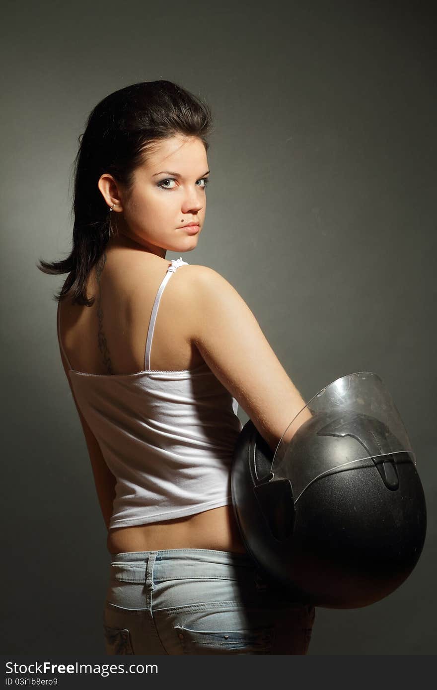 The girl with a motorcycle helmet on a gray background