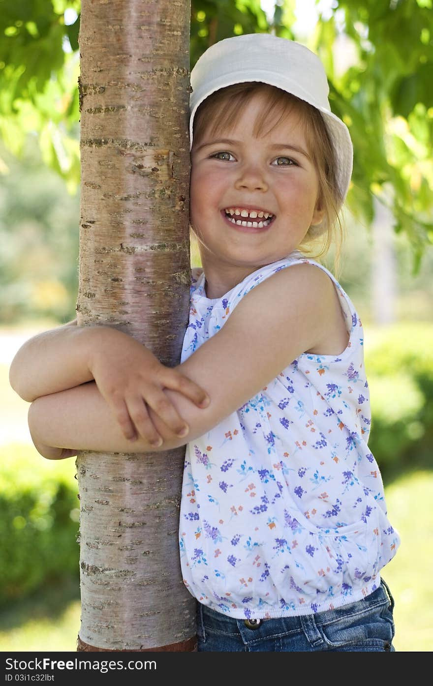 Little adorable girl posing by tree in the park. Little adorable girl posing by tree in the park