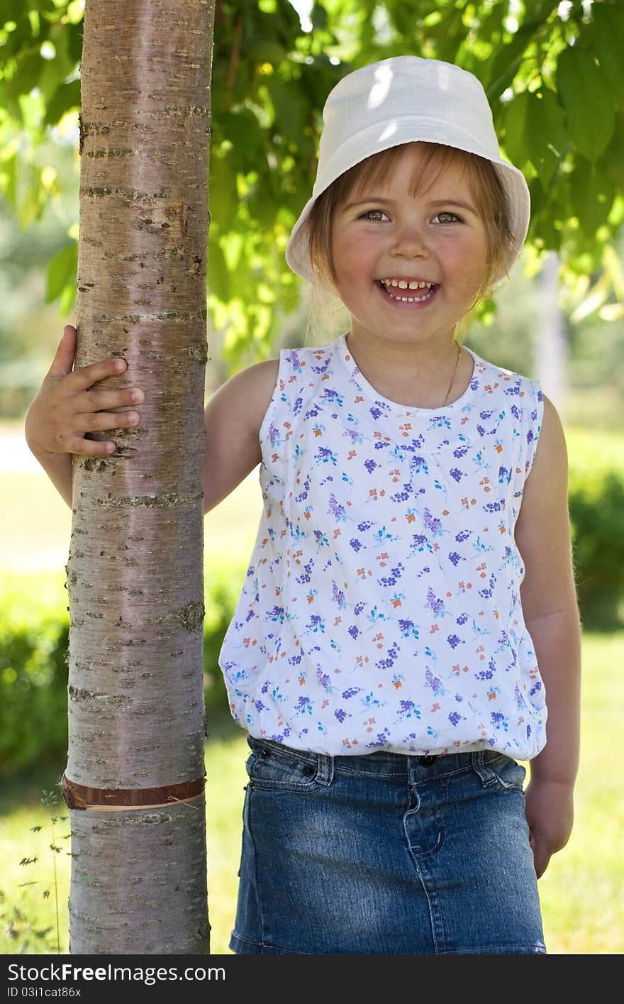 Little adorable girl posing by tree in the park. Little adorable girl posing by tree in the park