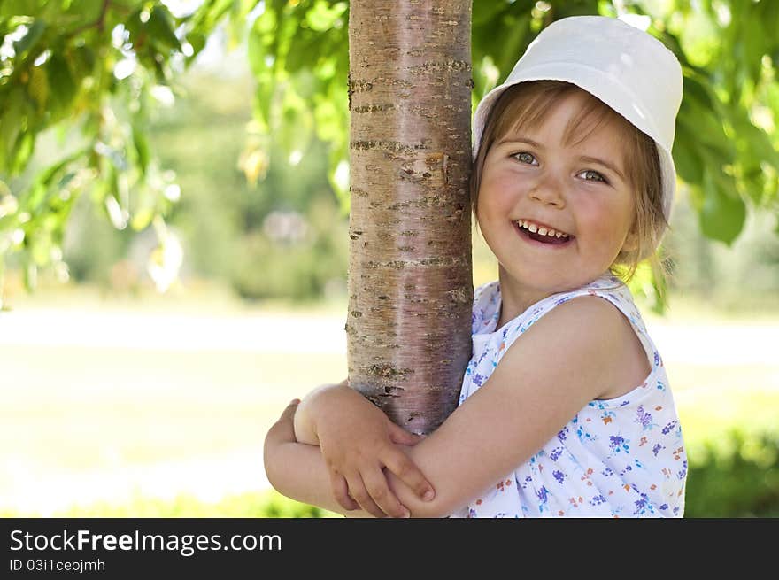 Little adorable girl posing by tree in the park. Little adorable girl posing by tree in the park