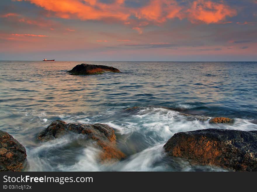 Sunset on the rocky coast of tropical island