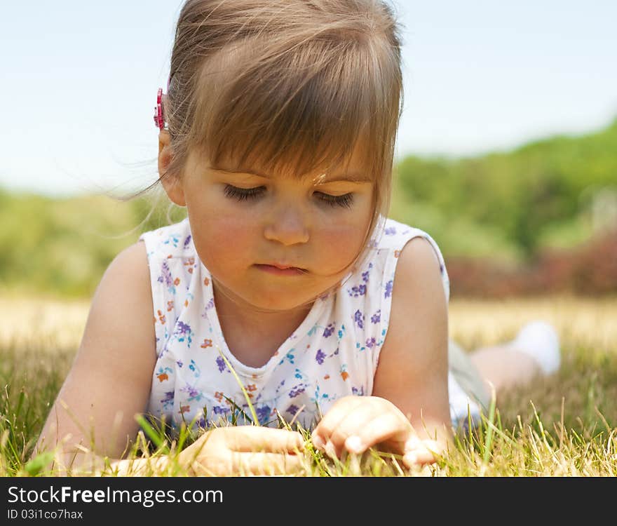 Little girl lying on grass in the park