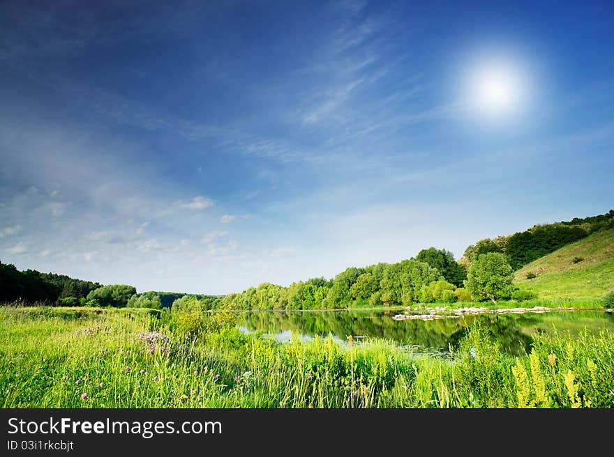 Small river and sun in the blue sky. Small river and sun in the blue sky.