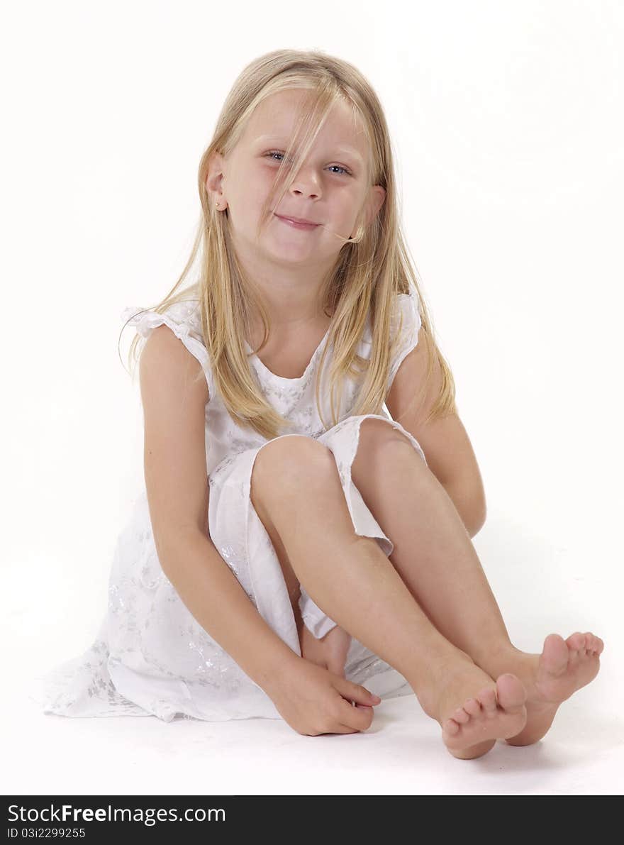 Cute little girl on white background, with a smile, whearing a white dress. Cute little girl on white background, with a smile, whearing a white dress.