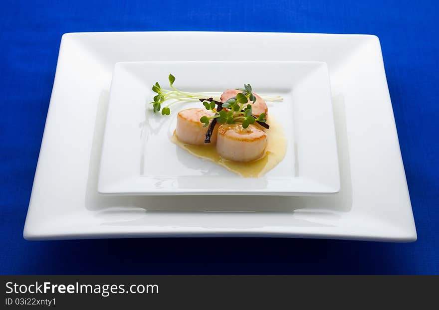 Scallop seafood appetizer with vanilla stick and sauce.