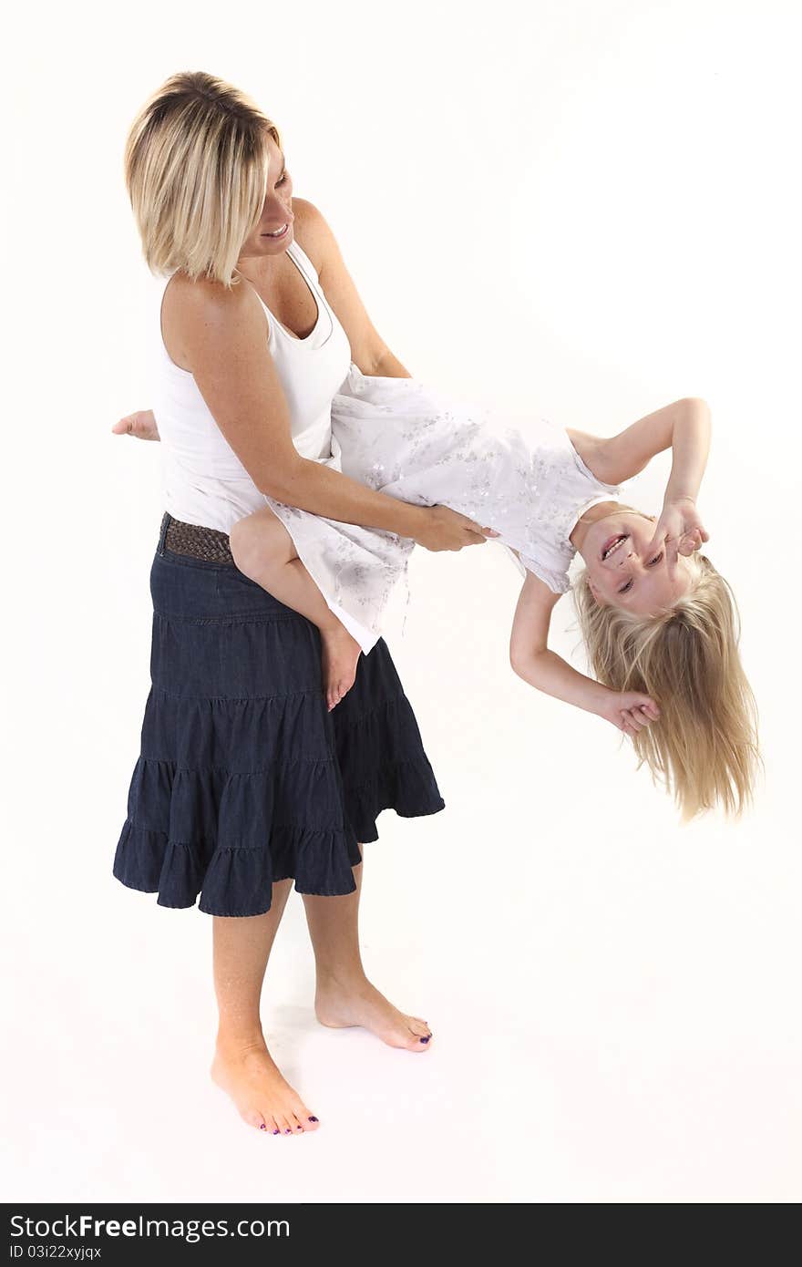 Blonde mother and daughter playing around in studio.