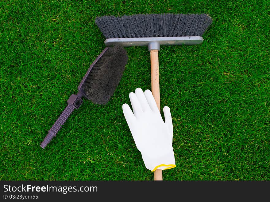 Brushes and a glove on a green grass