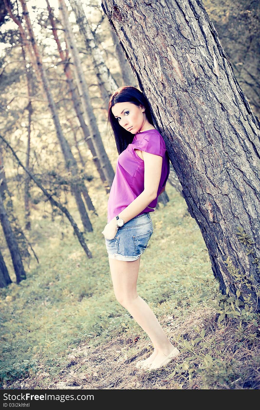 Beautiful Brunette Standing Near A Tree