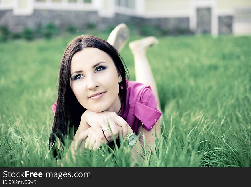 Beautiful young girl lying on the grass