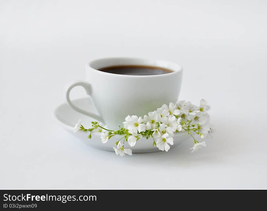 A cup of black coffee with flowers