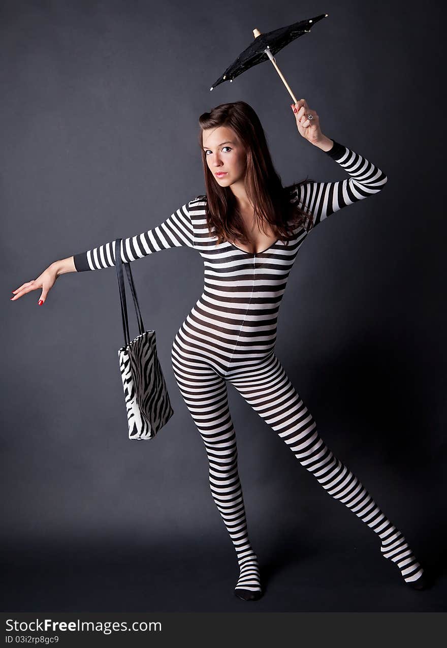 A portrait of a gorgeous young model, wearing a striped bodysuit and holding a matching purse and parasol. A portrait of a gorgeous young model, wearing a striped bodysuit and holding a matching purse and parasol