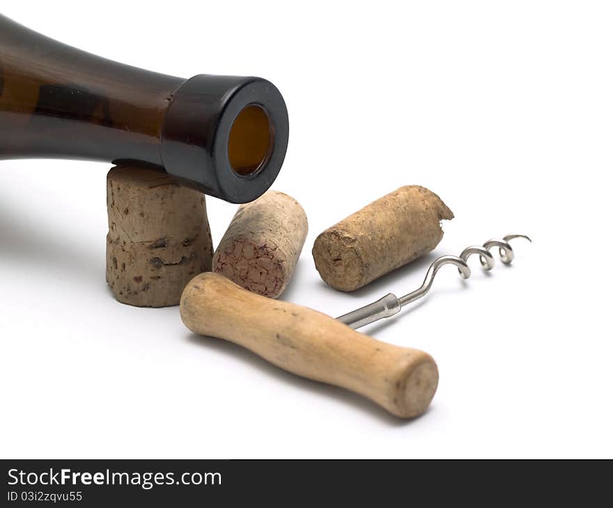 Several corks with corkscrew lie near a wine bottle