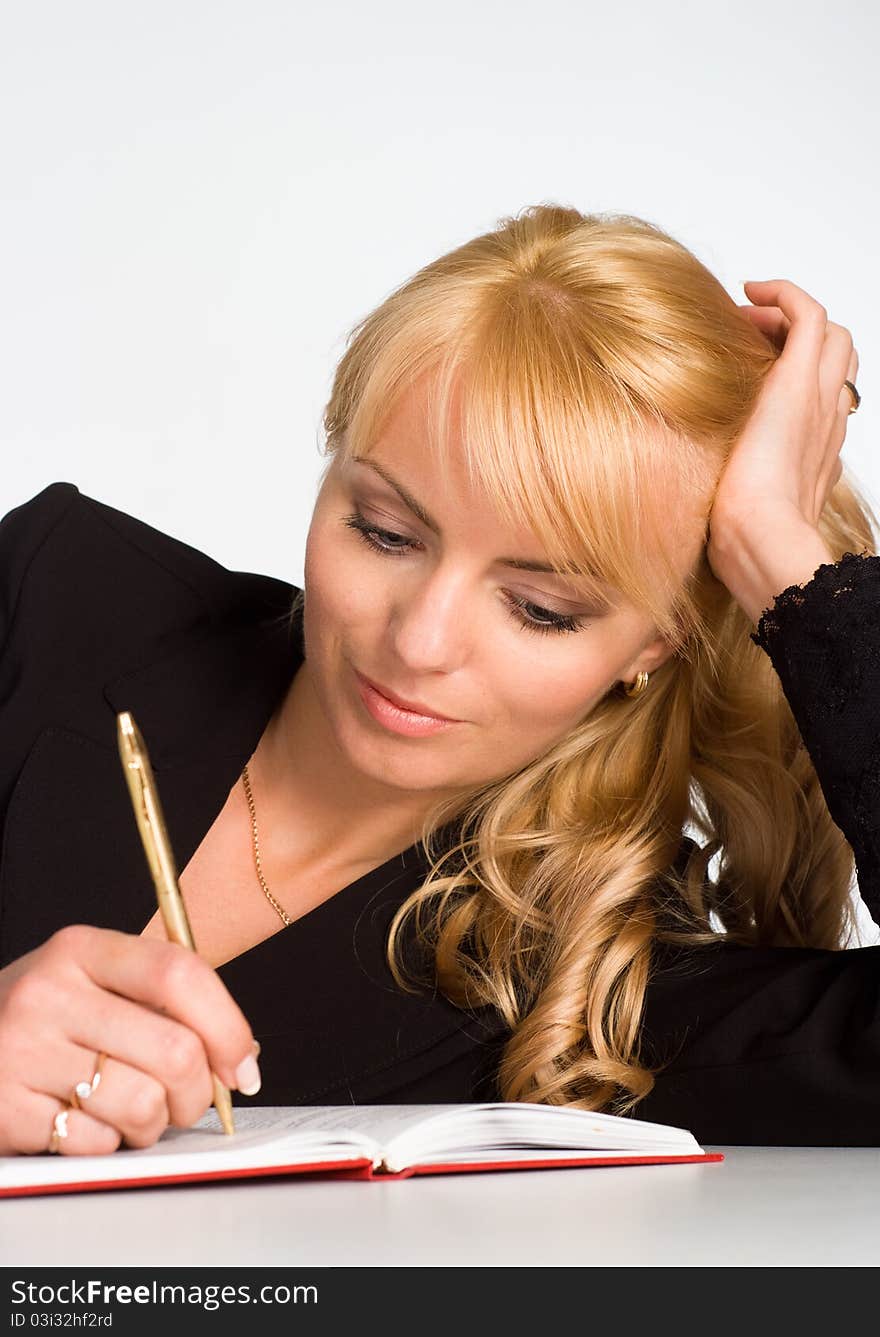 Beautiful young woman writing at the table