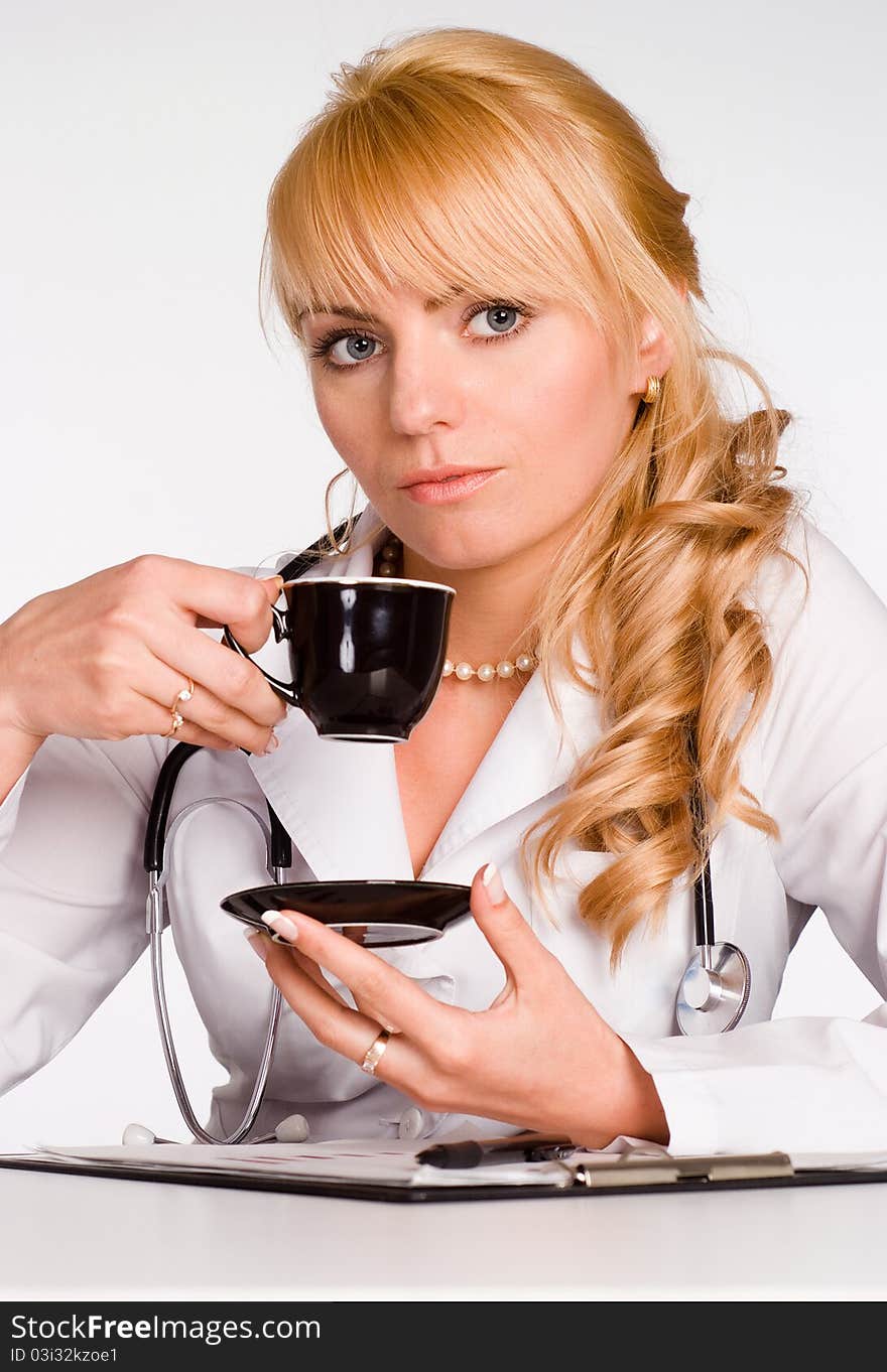 Young doctor drinks tea at the table