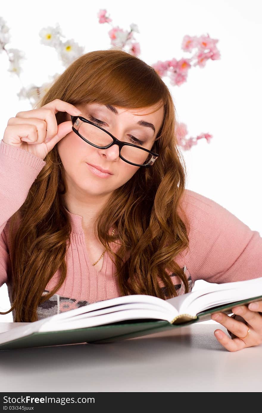 Clever girl reading a book at the table. Clever girl reading a book at the table