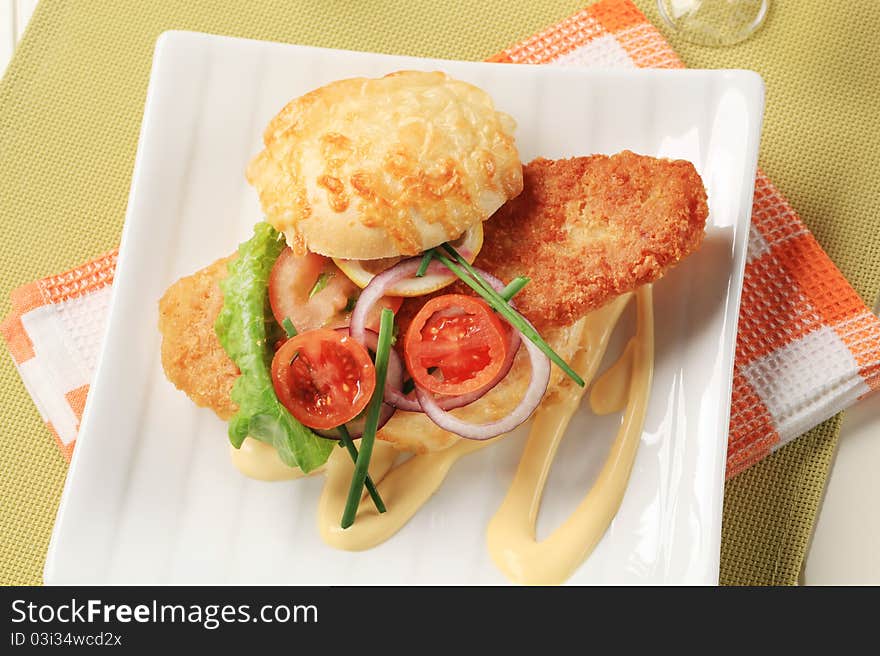 Fried fish sandwich with vegetable garnish and mayonnaise