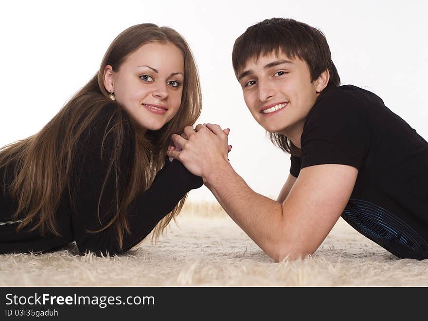 Portrait of a cute young couple lying on the carpet. Portrait of a cute young couple lying on the carpet