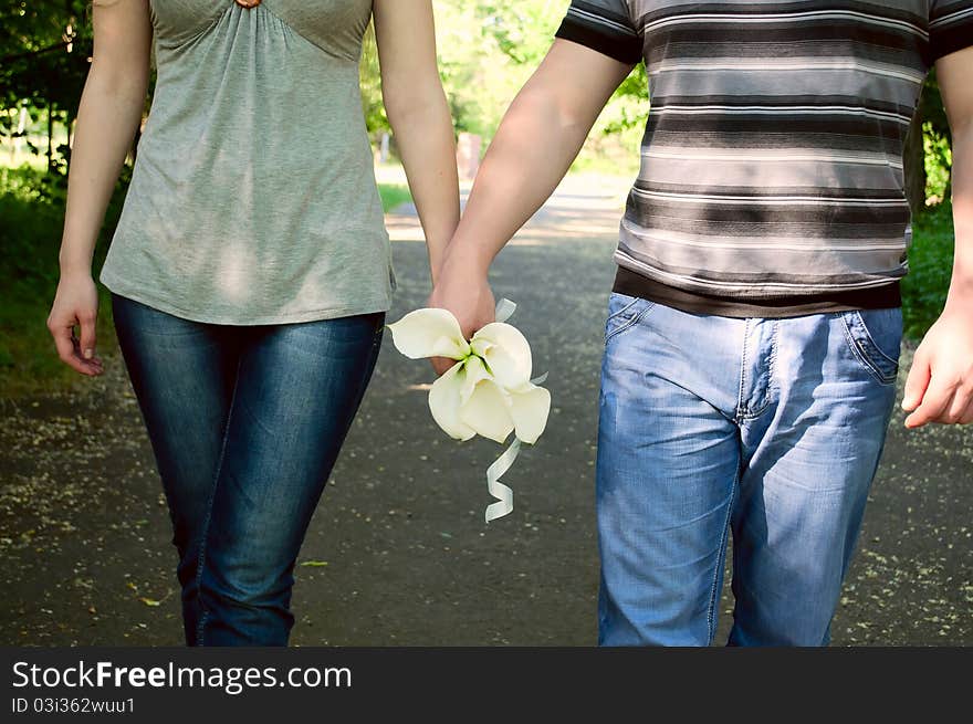 The loving couple bears flowers in hands