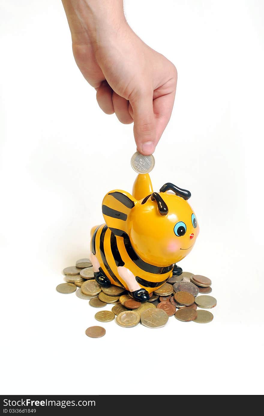 Droping a coin into a bee shaped piggy bank. Droping a coin into a bee shaped piggy bank