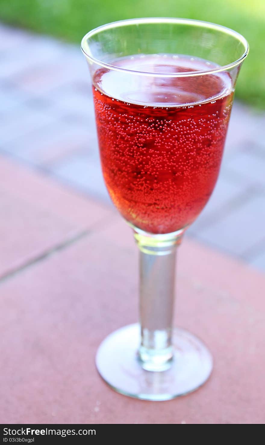 Sweet raspberry soda in a transparent glass on the terrace