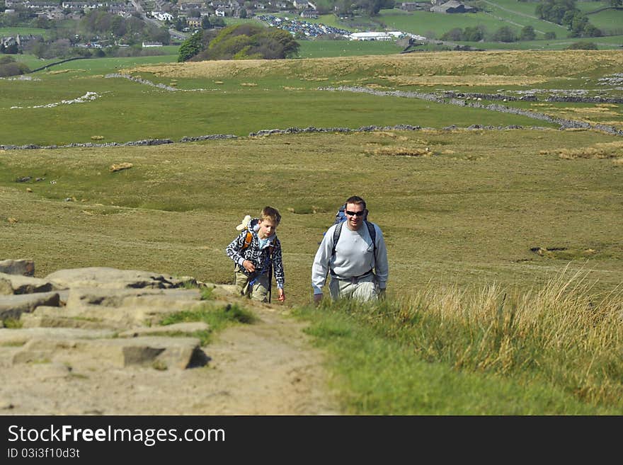 Active father & son hiking on hill in countryside