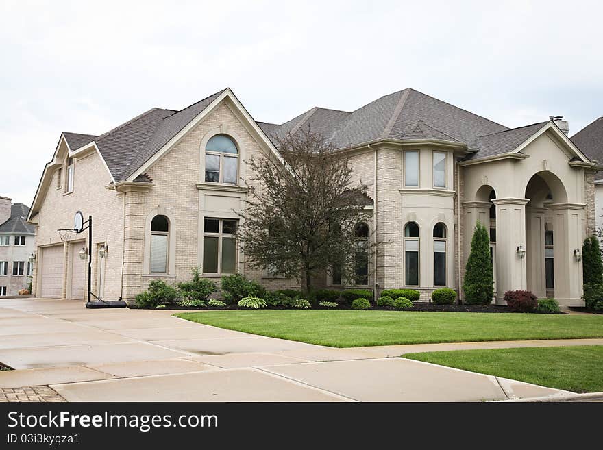 Image of a single family home with many windows and beautiful landscaping. Image of a single family home with many windows and beautiful landscaping.