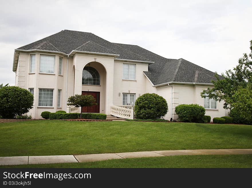 Image of a single family home with many windows and beautiful landscaping. Image of a single family home with many windows and beautiful landscaping.