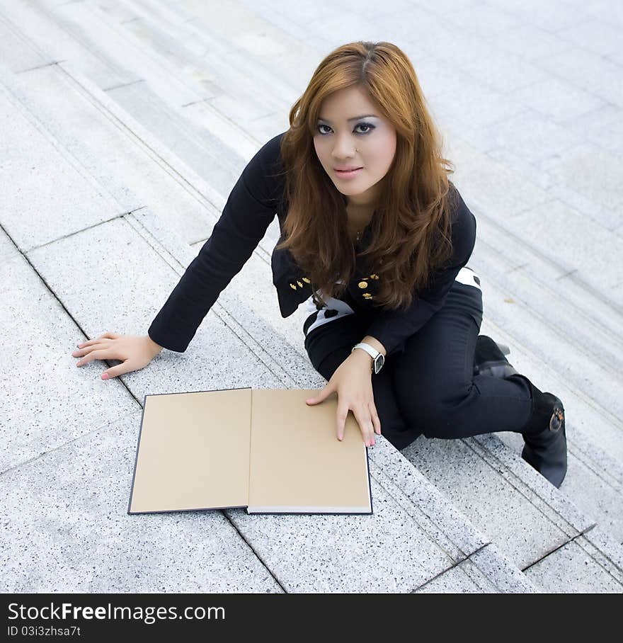 Young beautiful woman reading a book on the stairs. Young beautiful woman reading a book on the stairs