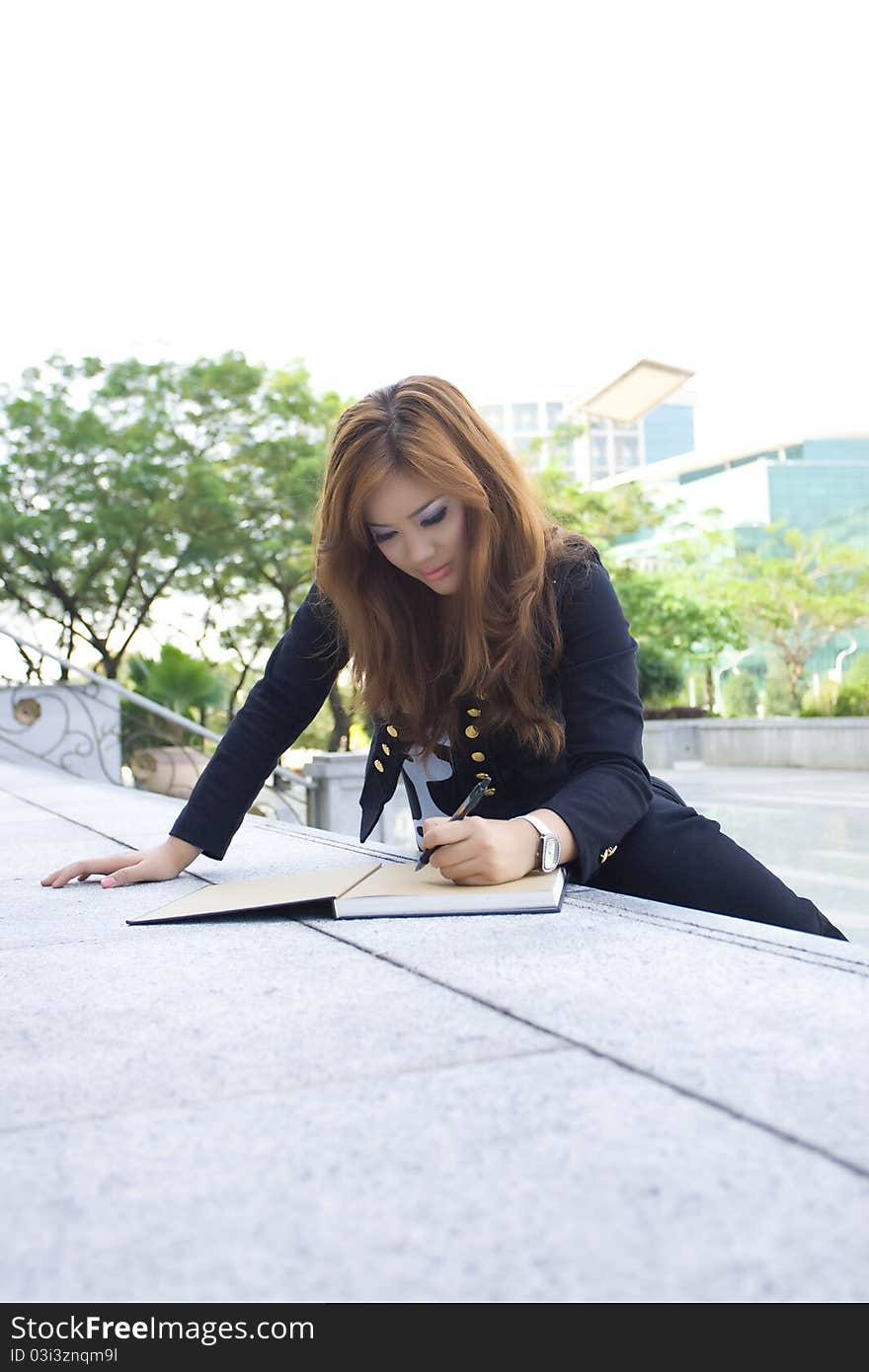 Young beautiful woman writing a book on the stairs. Young beautiful woman writing a book on the stairs