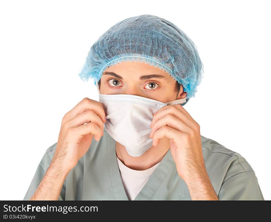 Young doctor wearing mask and medical cap looking at camera