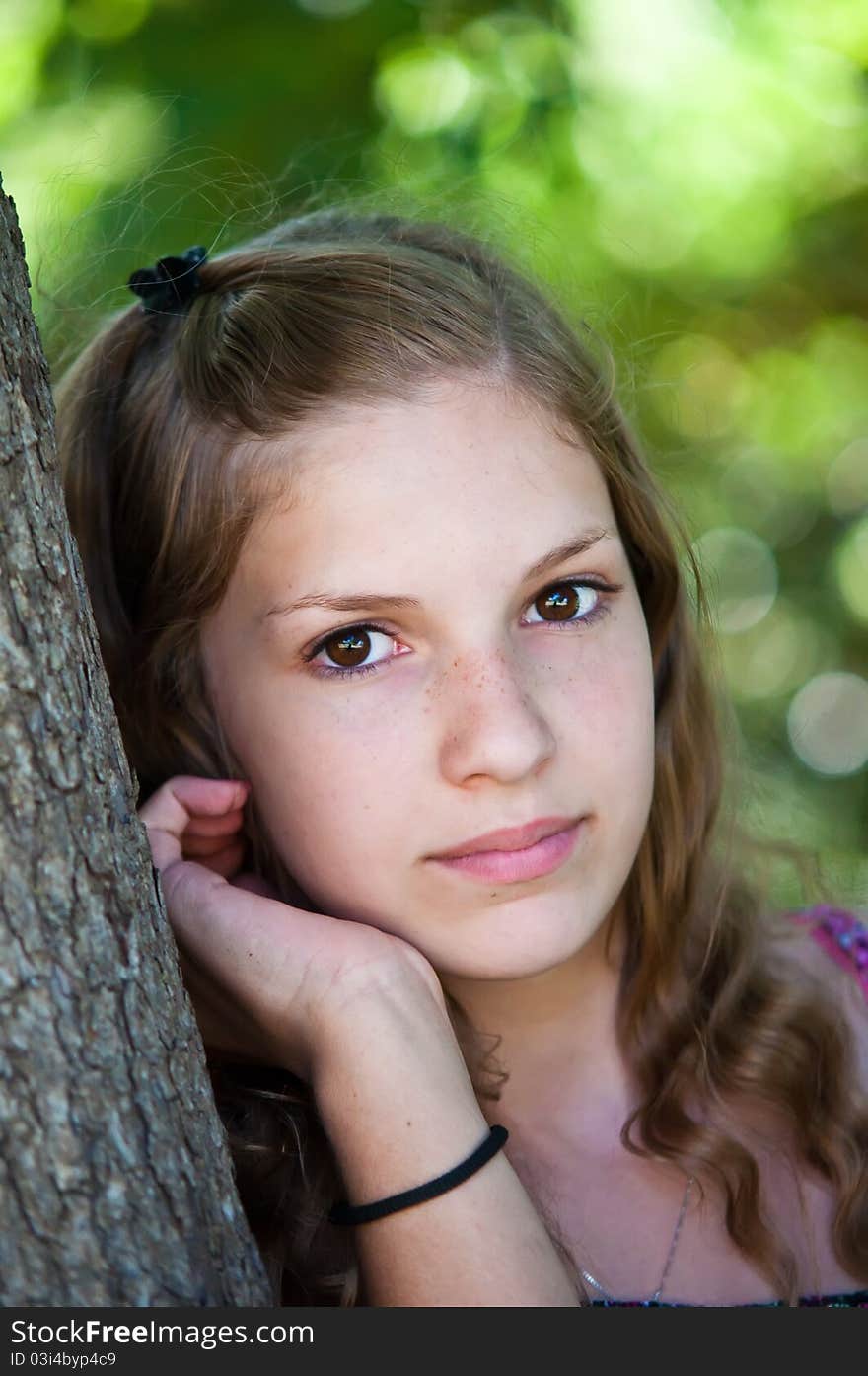 Portrait of a teen girl near the tree. Portrait of a teen girl near the tree.