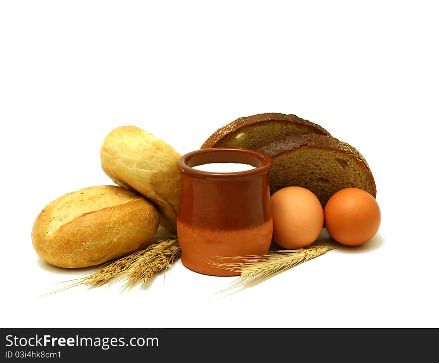 Milk in clay pot, buns, bread and eggs isolated on white background