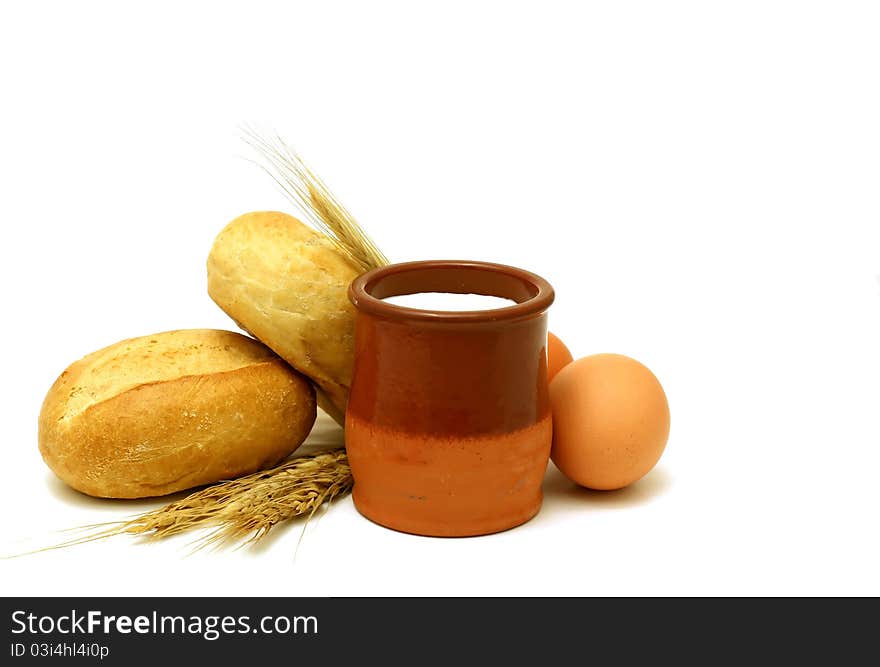 Milk in clay pot, buns and eggs isolated on white