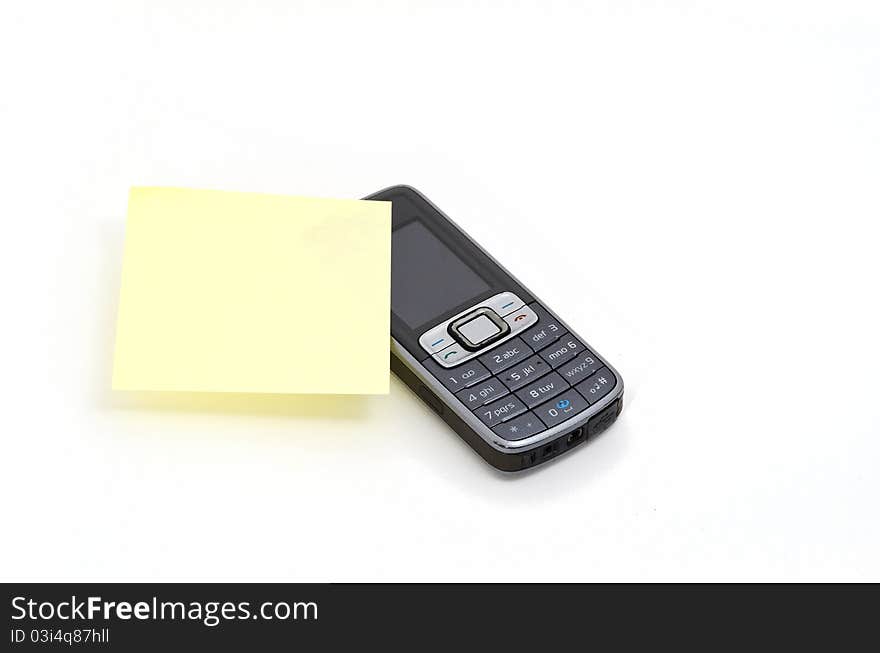 Yellow memo stick to a mobile phone. Yellow memo stick to a mobile phone