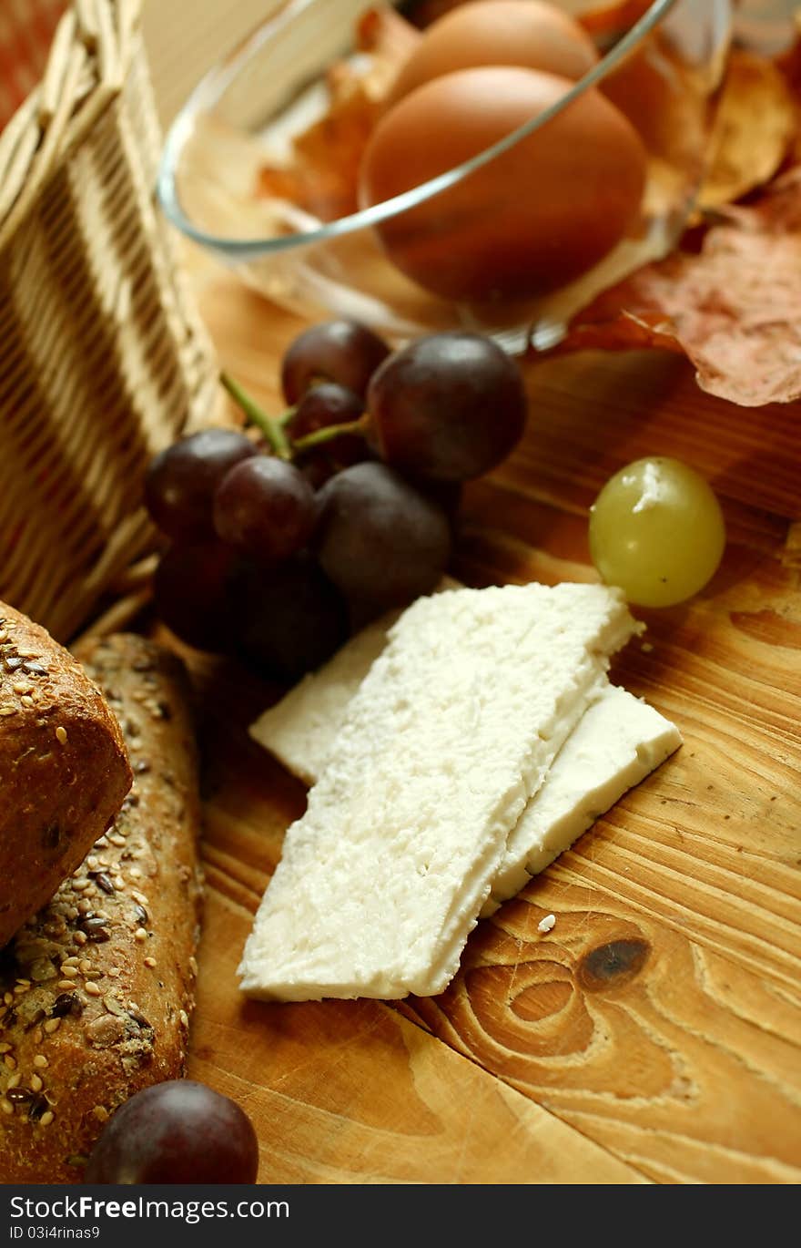 Goat cheese and grapes on old wooden board