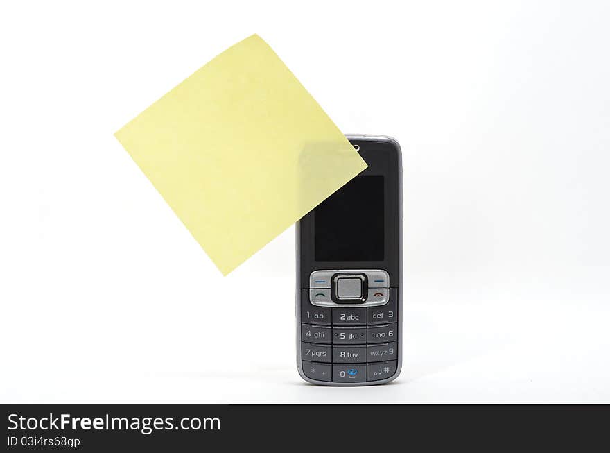 Yellow memo stick to a mobile phone. Yellow memo stick to a mobile phone