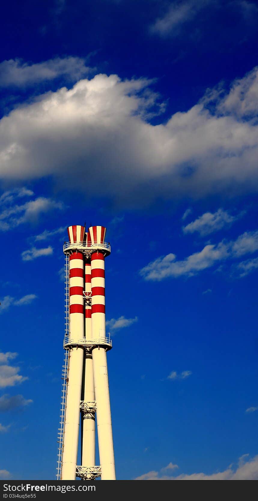 Chimney with red circle under blue sky on the factory