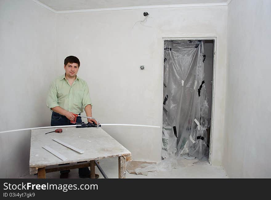 An image of a man making repairs in a room