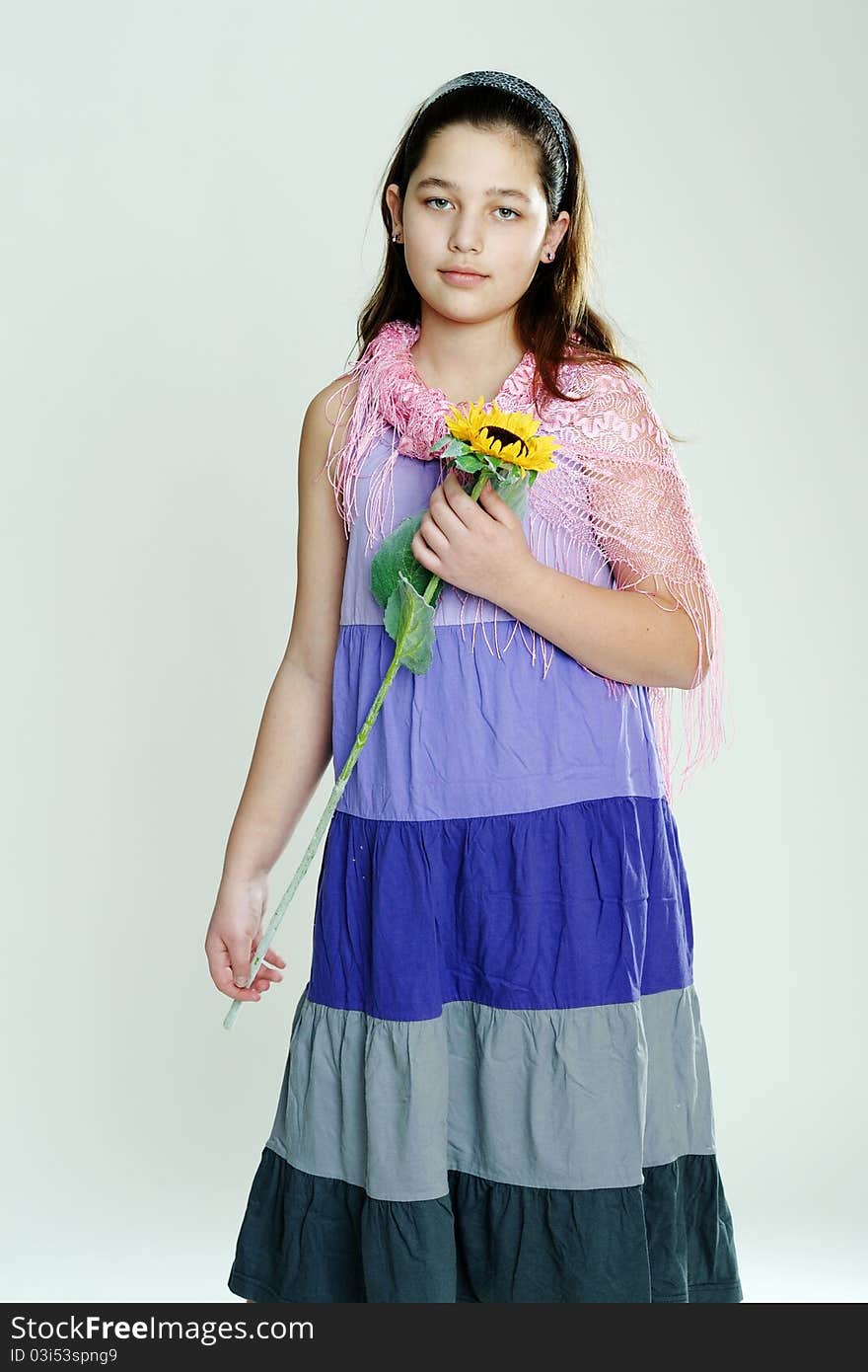 An image of a young girl with a yellow flower. An image of a young girl with a yellow flower