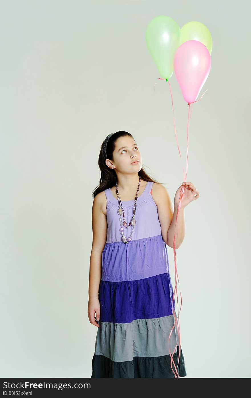 An image of a young girl with three balloons